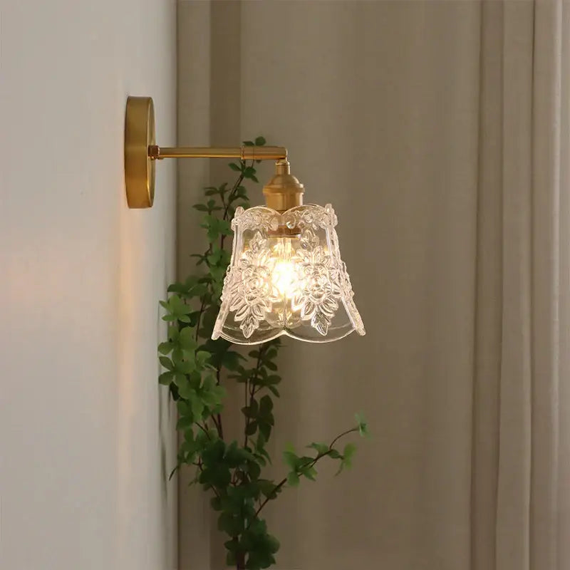 Antique brass wall sconce pendant light with clear intricately etched glass shade in polished copper for dining room