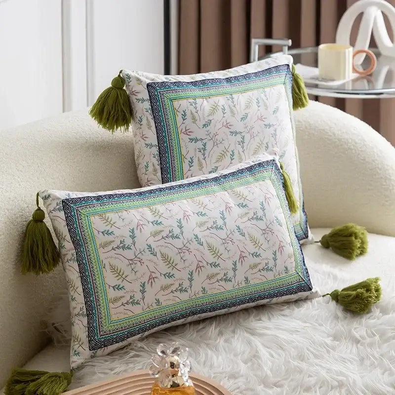 Two rectangular pillow covers with ethnic botanical print and olive green tassels in teal and navy cover set