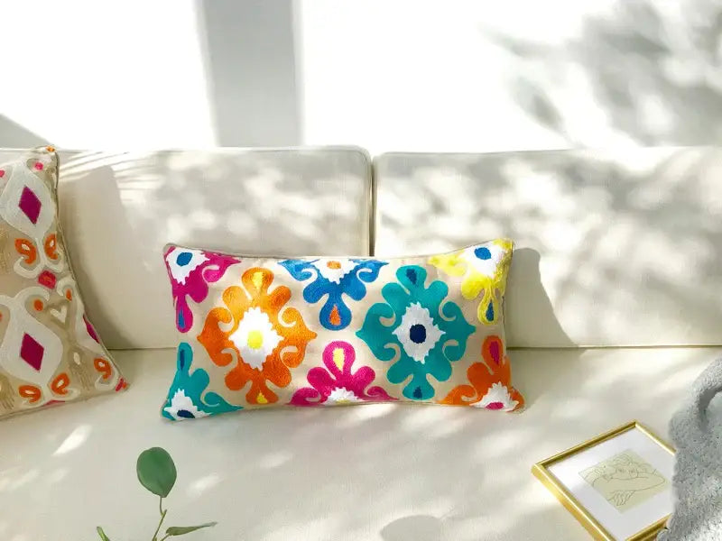 Vibrant rectangular pillow cover with embroidered floral ikat pattern in pink orange blue teal and ethnic tassels