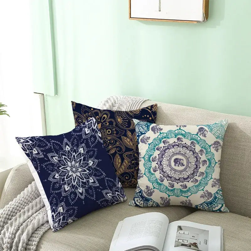 Three decorative decorbites geometric square pillowcases with mandala and elephant patterns in teal and gold colors