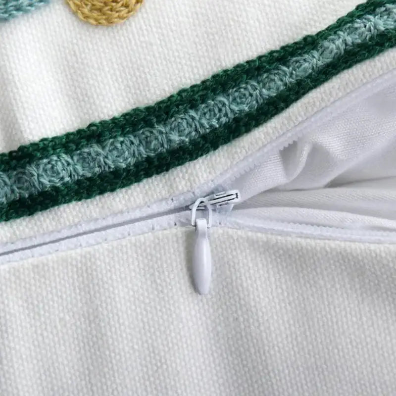 White zipper with oval pull tab on ethnic style floral canvas pillow cover featuring embroidered green stripe decorbites ethnic style