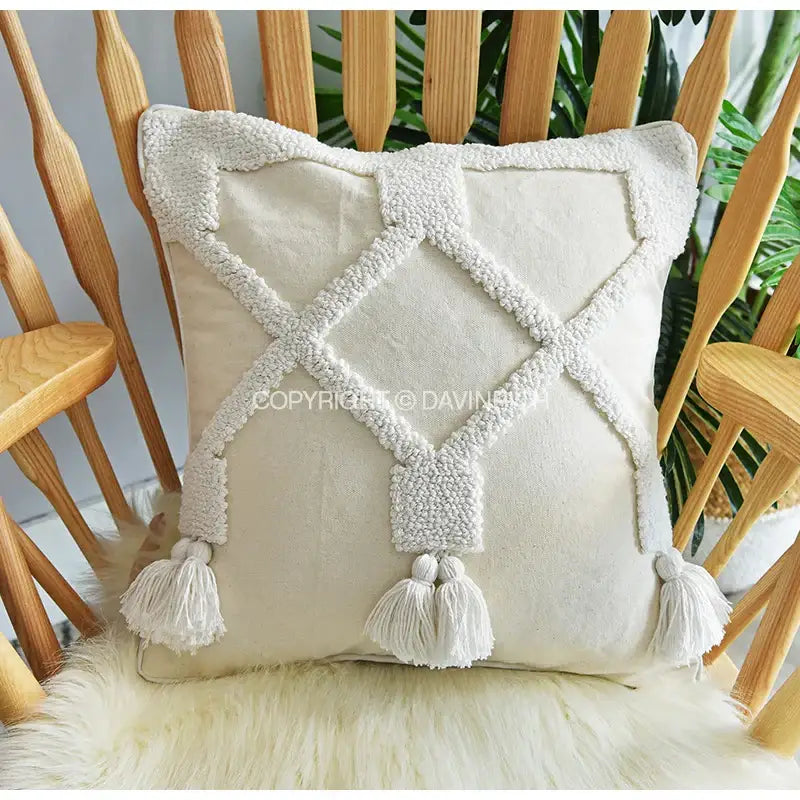 Cream-colored decorbites ethnic tufted cushion with woven diamond pattern and tassels for living room decor