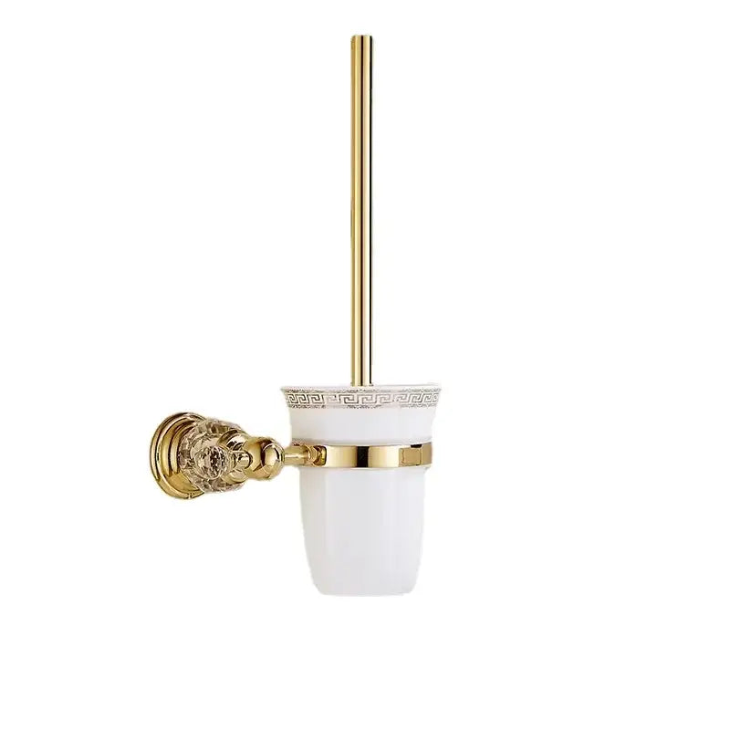 Gold-finished toilet brush holder with white ceramic cup featuring greek key pattern in decorbites crystal bathroom rack