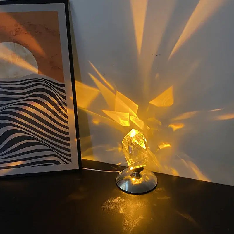 A golden faceted crystal diamond table lamp with a metallic base casting warm geometric patterns for bedroom lighting
