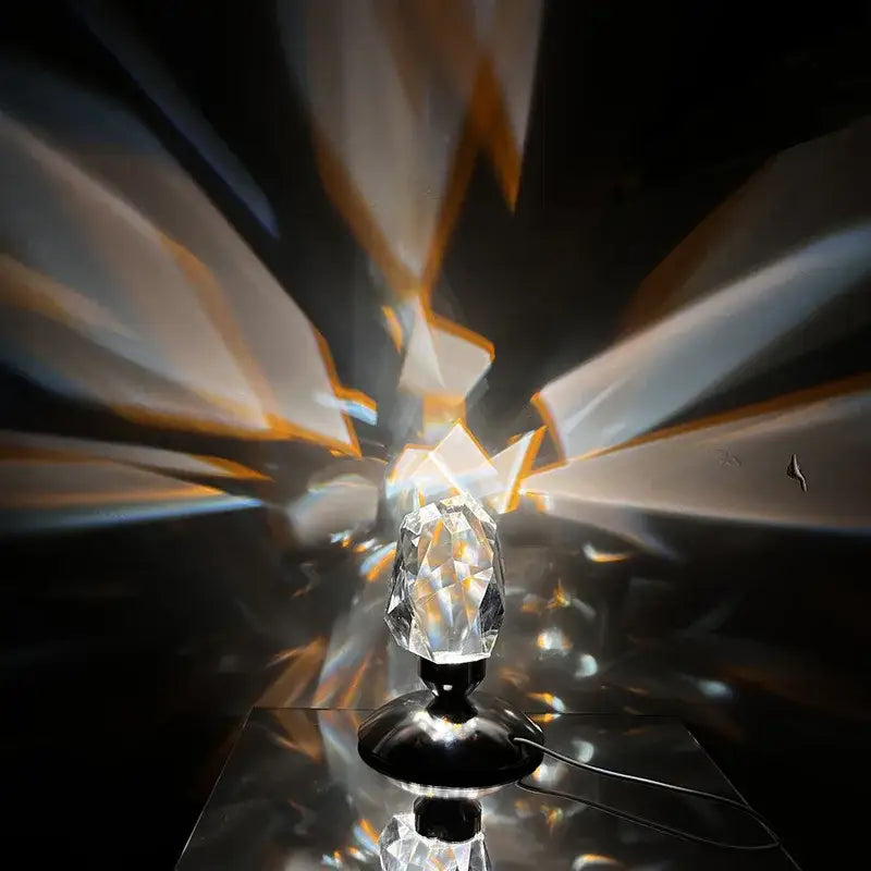 Faceted crystal diamond table lamp with black base casting radiant geometric light patterns for bedroom lighting