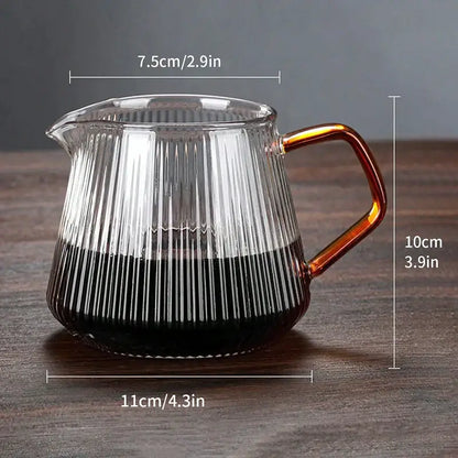 Faceted dark tinted diamond glass coffee carafe with amber handle filled with dark liquid and filter cup