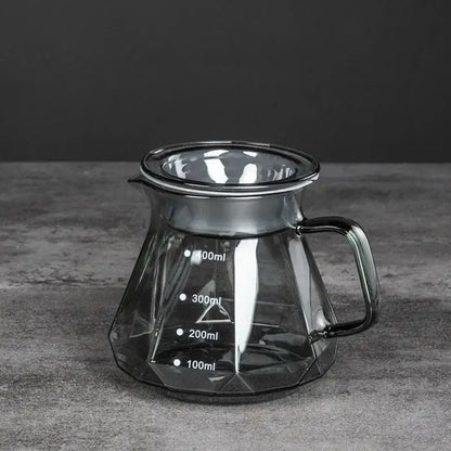 A sleek dark tinted diamond glass coffee carafe with geometric filter cup and milliliter measurement markings
