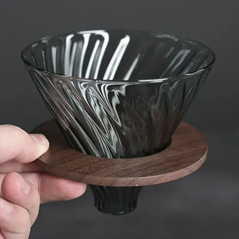 Faceted dark tinted diamond glass coffee carafe with dark gray ribbed glass filter cup and wooden base for kitchen use