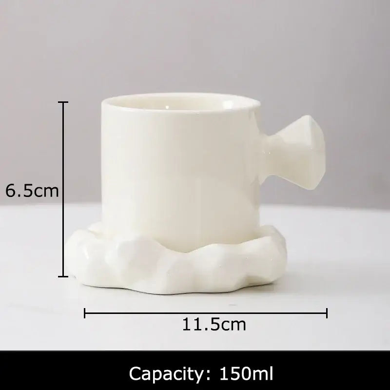 White ceramic coffee mug with sculpted cloud-like base and handle from faceted light blue porcelain mug set