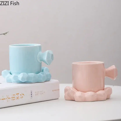 Pastel blue and pink ceramic mug set with faceted handles and matching saucers for kitchen decor and coffee use