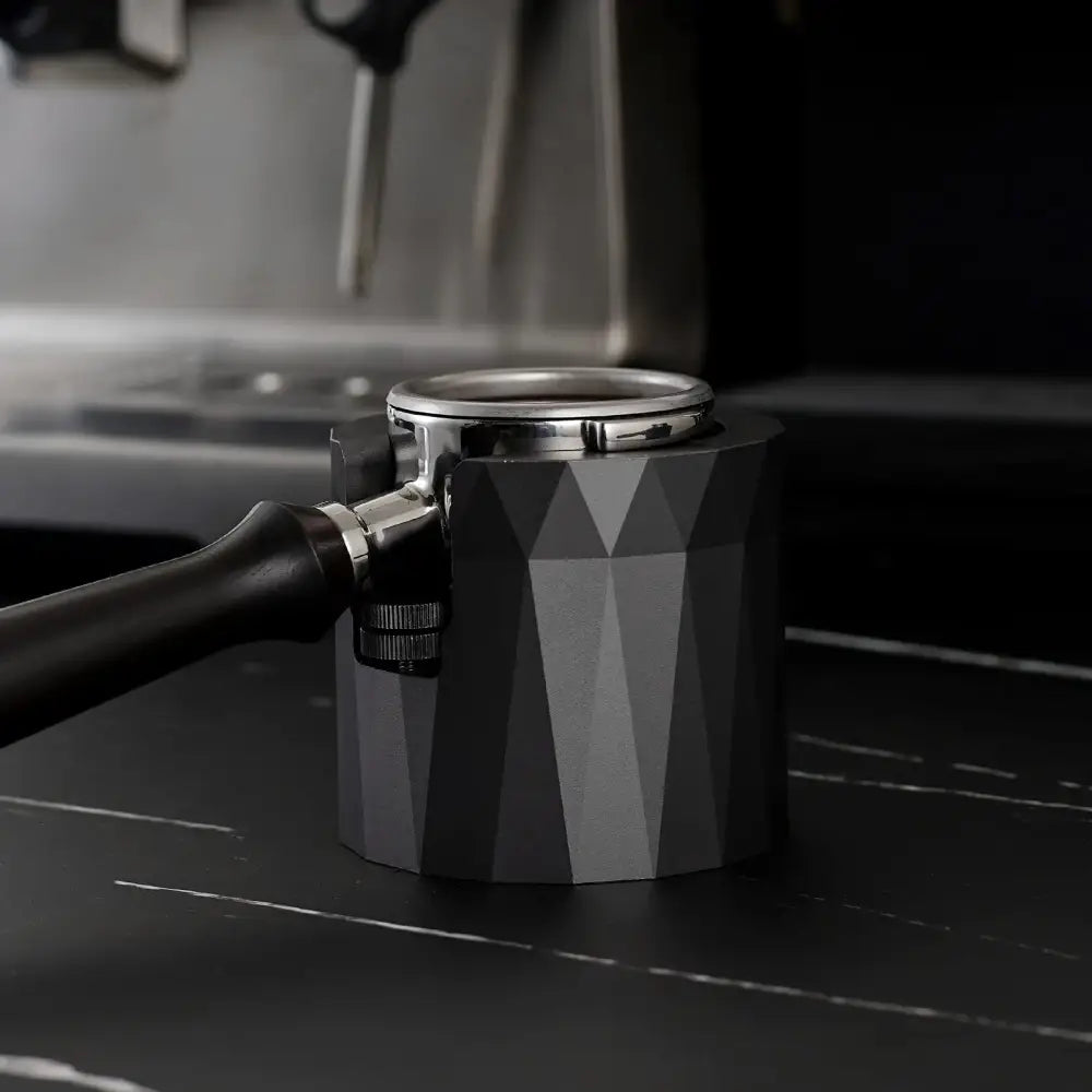 Faceted matte black metal espresso portafilter holder with geometric pattern designed as a kitchen stand for espresso portafilter