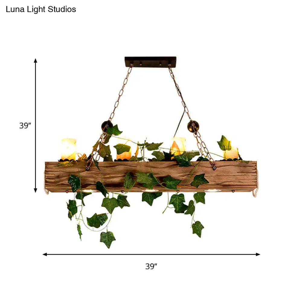 Rustic wooden linear island chandelier with warm glowing candles and faux green ivy for farmhouse dining rooms