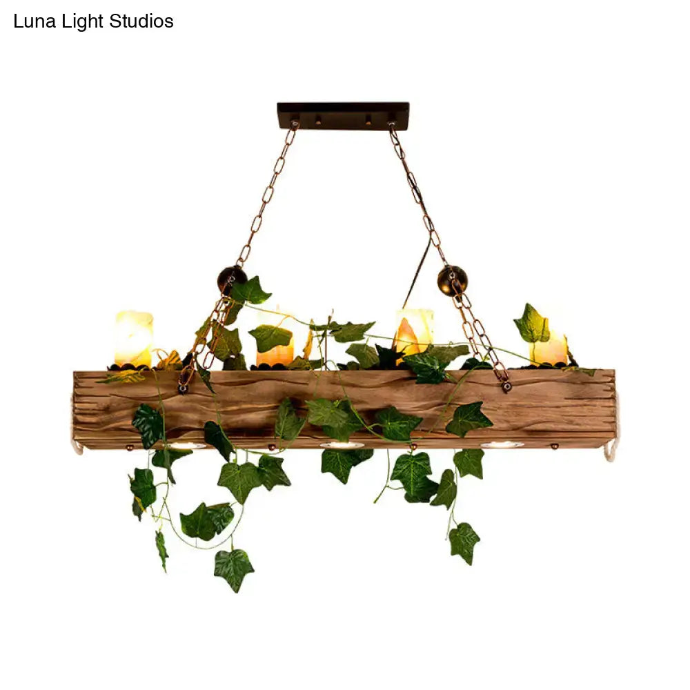Rustic wooden linear island chandelier with green ivy and candle-like bulbs designed for farmhouse dining rooms