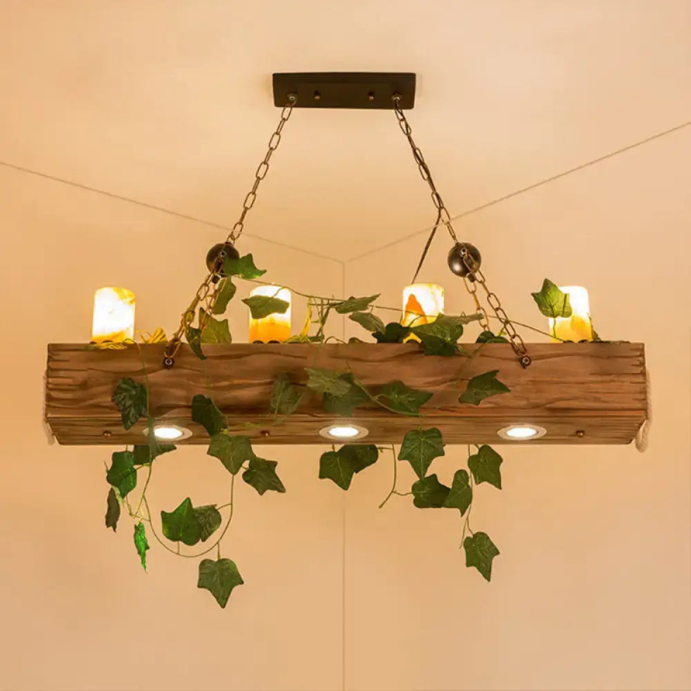 Rustic wooden linear island chandelier with green ivy vines and warm yellow candle lights for farmhouse dining rooms