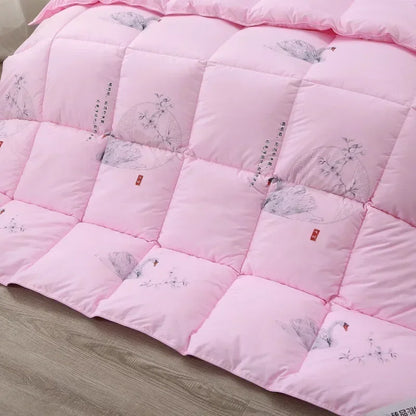 Pink quilted white goose down quilt with gray bird and blossom illustrations and red tags for winter bedding