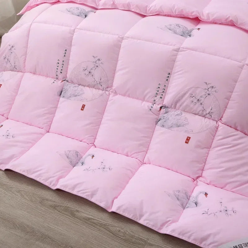 Pink quilted white goose down quilt with gray bird and blossom illustrations and red tags for winter bedding