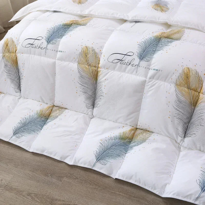 White goose down quilt with embroidered blue and gold feathers and feather script for winter bedding use
