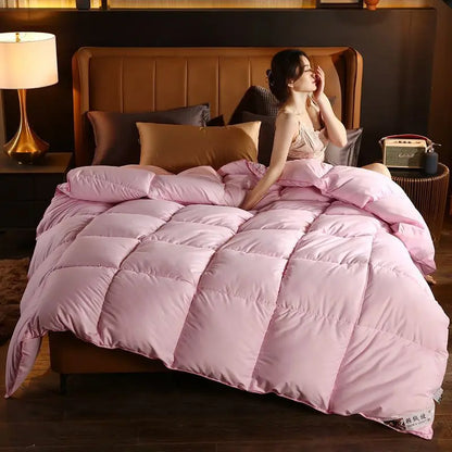 Soft pink quilted comforter with plush texture and subtle stitching made from high-quality white goose down