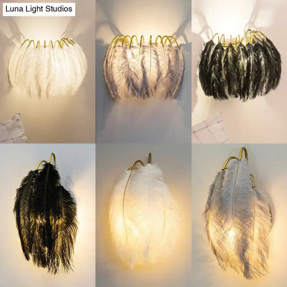 Elegant feather gold wall light fixture with gold-toned metal frame and soft white, gray, and black feathers for bedroom