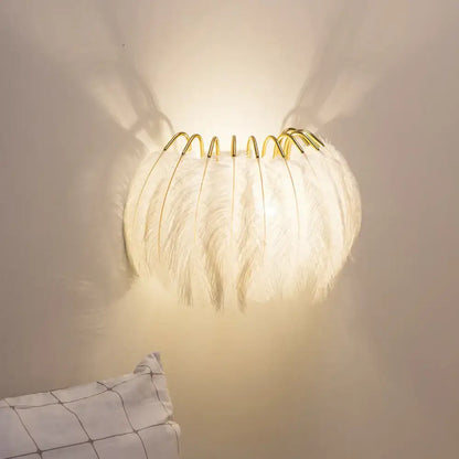 White feathered wall light fixture with gold-toned metal frame designed as a bedroom sconce wall light