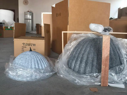 A light blue ribbed felt pendant light acoustic office dome wrapped in clear plastic packaging