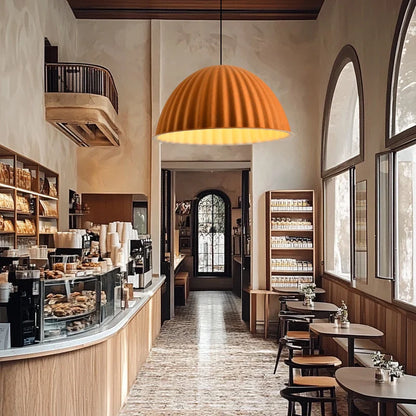 A warm orange-toned felt pendant light with ribbed design hanging from ceiling for acoustic office use