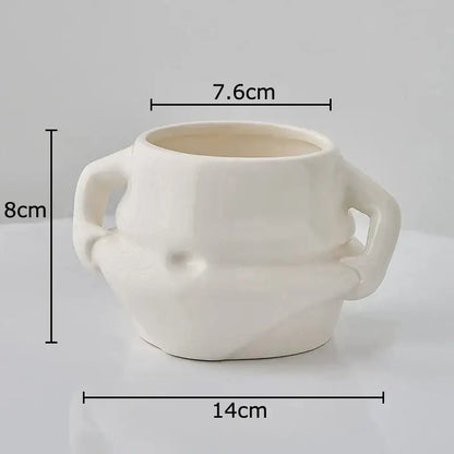 Cream-colored ceramic planter with two sculpted handles and textured rounded body in festive white santa claus ceramic mug set