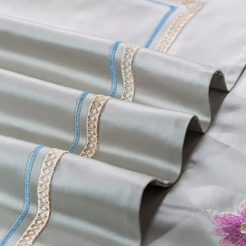 Light gray satin pillowcase with delicate blue and gold embroidered trim from floral 200s embroidered egyptian cotton bedding set