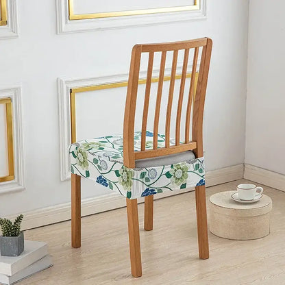Floral blue and green elastic print chair cover made of stretchy fabric fitting snugly over a wooden dining chair