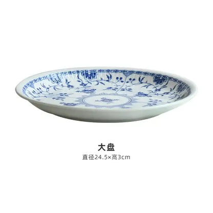 White ceramic plate with intricate blue floral and vine patterns from a floral blue and white ceramic dining set