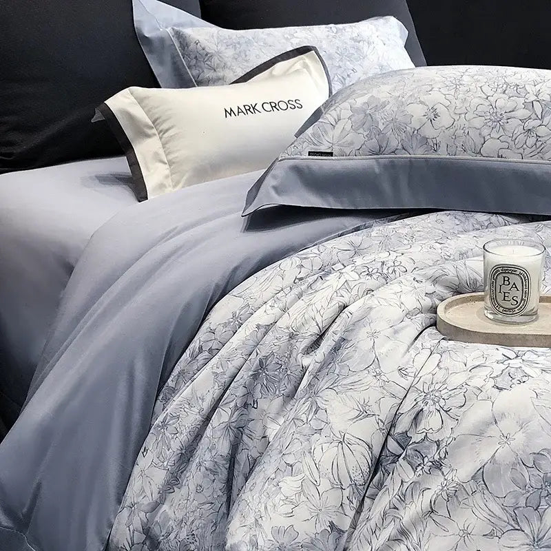 Gray floral-patterned duvet cover with matching pillowcases and a cream mark cross pillow in egyptian cotton bedding sets