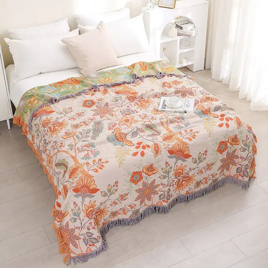 A cream-colored jacquard cotton gauze sofa cover with vibrant floral pattern and gray fringe for living room decorbites throw