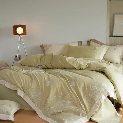Soft sage green satin duvet cover set with delicate white floral embroidery and cream ruffled edge for bedroom decor