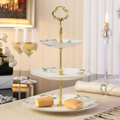 Three-tiered serving stand with gold-toned metal frame and white floral bone china fruit plates set for dining room use
