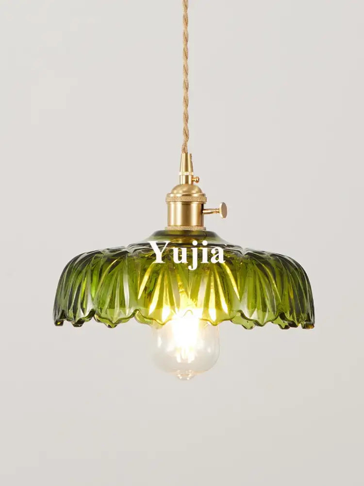 Floral green glass pendant light with a ruffled translucent green glass shade and brass fixture for kitchen use