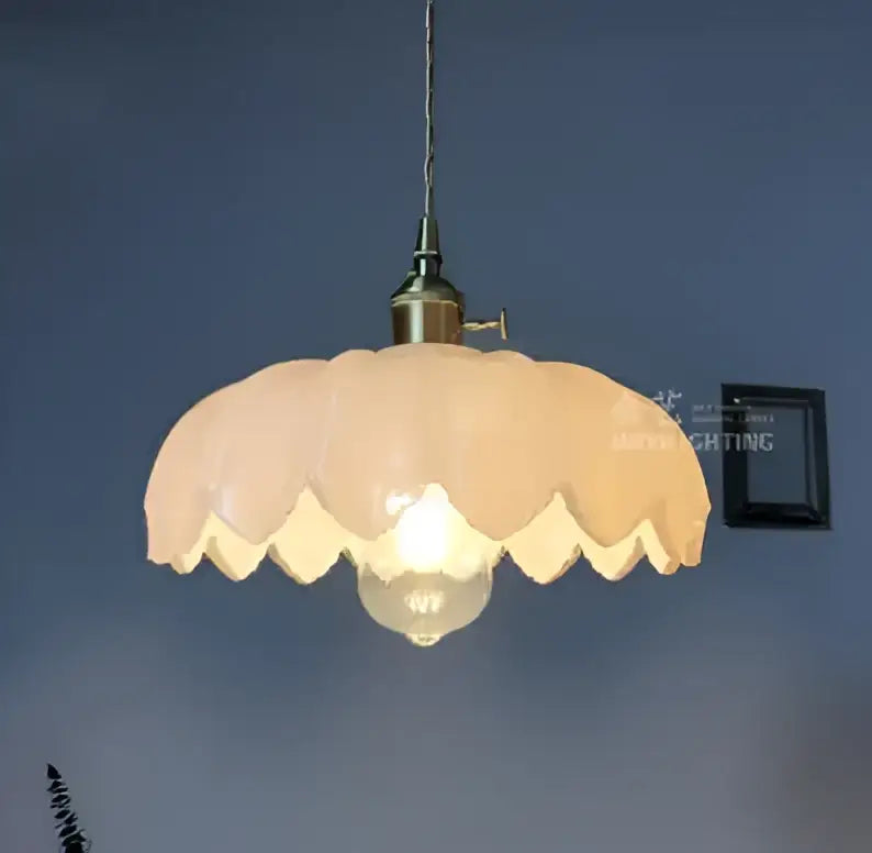 Vintage-style glass pendant light with soft peach scalloped shade and golden brass hardware for living room lighting