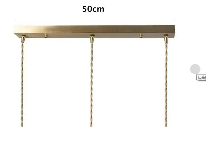A brass-colored rectangular pendant light fixture with twisted copper chains for floral green glass pendant lights