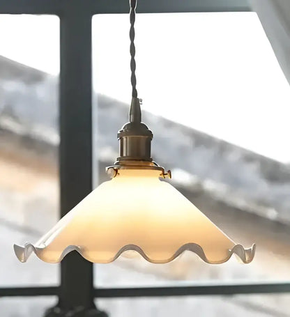 Antique brass-finished glass pendant light with warm frosted scalloped shade for living room lighting