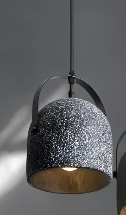 Industrial-style pendant lights with speckled gray concrete exterior and brass interior for living room lighting