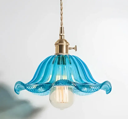 A delicate blue glass pendant light with fluted design and golden brass hardware ideal for living room use