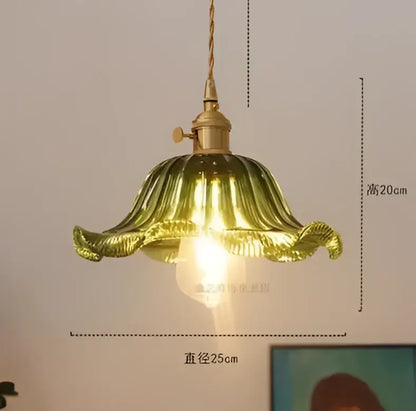 Golden glass pendant lights with petal-shaped design and brass hardware emitting warm glow for living room use