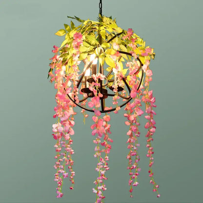 A delicate pink and yellow floral green plant lighting chandelier with cascading artificial blossoms on dark metal frame for dining room decorbites green plant