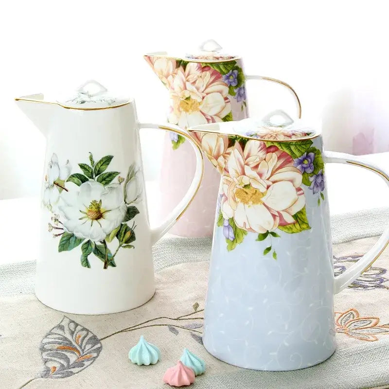 A delicate white floral light blue bone china tea set coffee pot decorated with pastel flowers and gold trim by decorbites bone