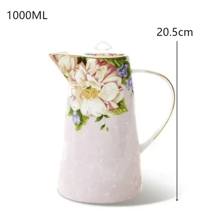 A delicate pink ceramic pitcher with white blossoms and purple accents from the decorbites bone tea set collection