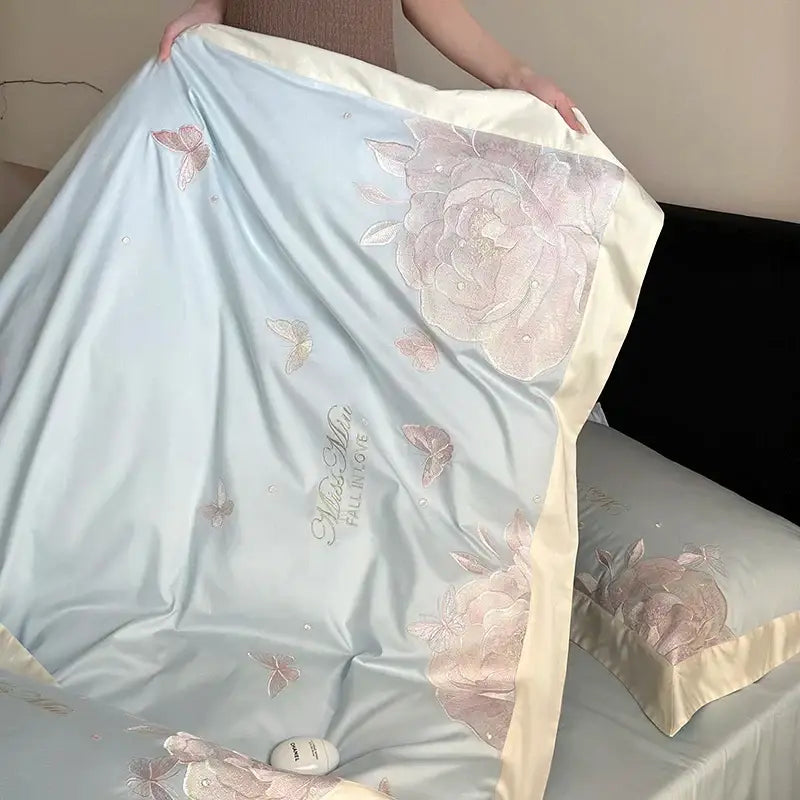 Light blue satin bedding set with pink floral embroidery and butterfly motifs on decorbites 1000tc Egyptian cotton
