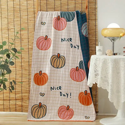 A soft light-colored cotton gauze adult quilted blanket featuring cartoon pumpkins and nice day print for decorbites bath towels decor