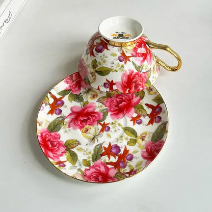 A porcelain coffee cup and saucer set with vibrant pink peonies green leaves purple berries and gold trim decorbites flowers pattern