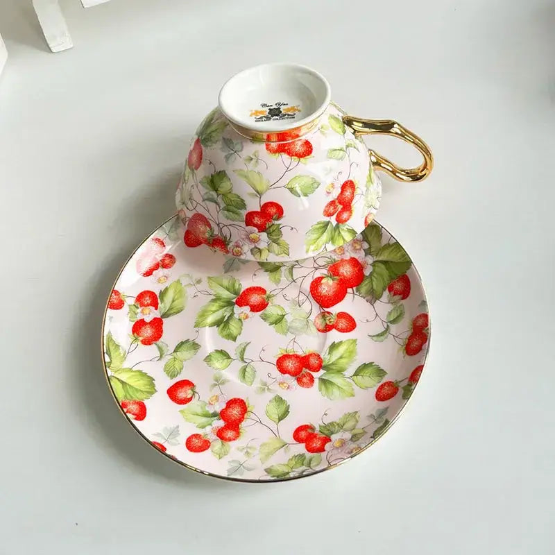Delicate porcelain coffee cup and saucer set with decorbites flowers pattern strawberry vine on soft pink background