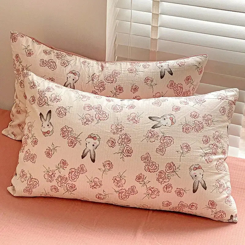 Cream-colored pillowcases with delicate pink roses and bunny illustrations in floral pink and cream cotton flower printed comforter set