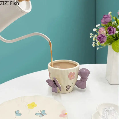 Cream-colored ceramic cup with pastel floral patterns and purple butterfly decorbites bowknot ceramic handle in saucer set